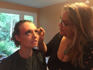 Emily applying Alisha's makeup