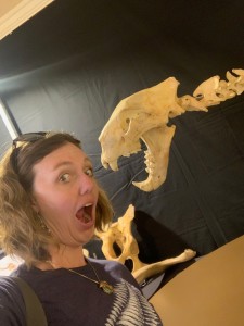 Alisha posing beside a prehistoric cat skeleton.